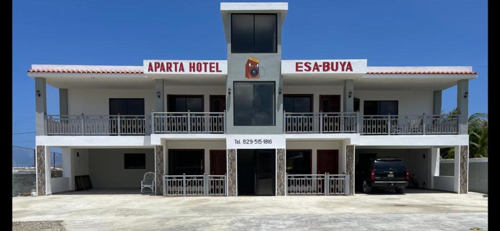 蒙特克里斯蒂省圣费尔南多Aparta Hotel Esa Buya的一座白色的大建筑,前面有停车位