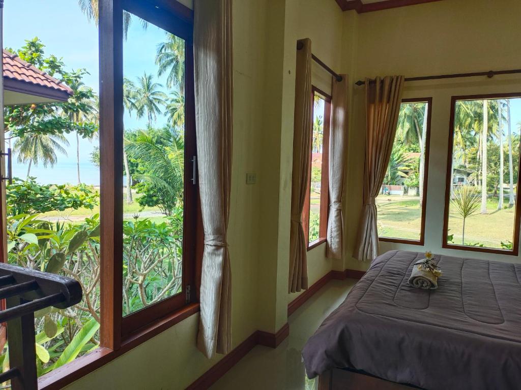 苏梅岛Links Sunset Beach House的客房设有一张床和享有美景的窗户。
