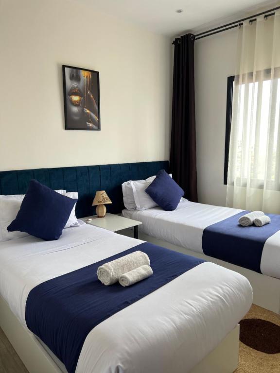 安齐拉贝Yvanka Appart'City Antsirabe的蓝色和白色的客房内的两张床