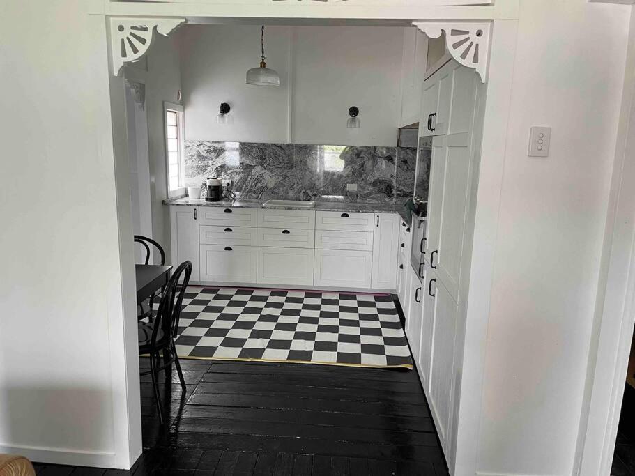 布里斯班Comfy Queenslander Cottage的厨房铺有黑白的格子地板。