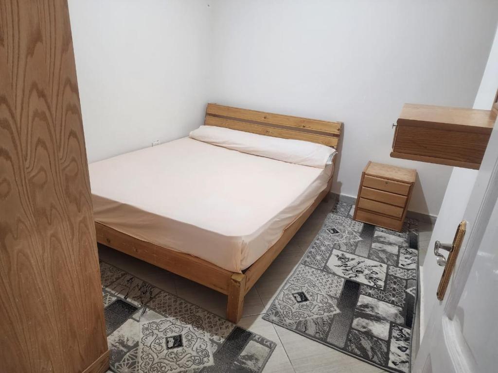 马特鲁港شقه الهاني的一间小卧室,配有一张床和一扇木门