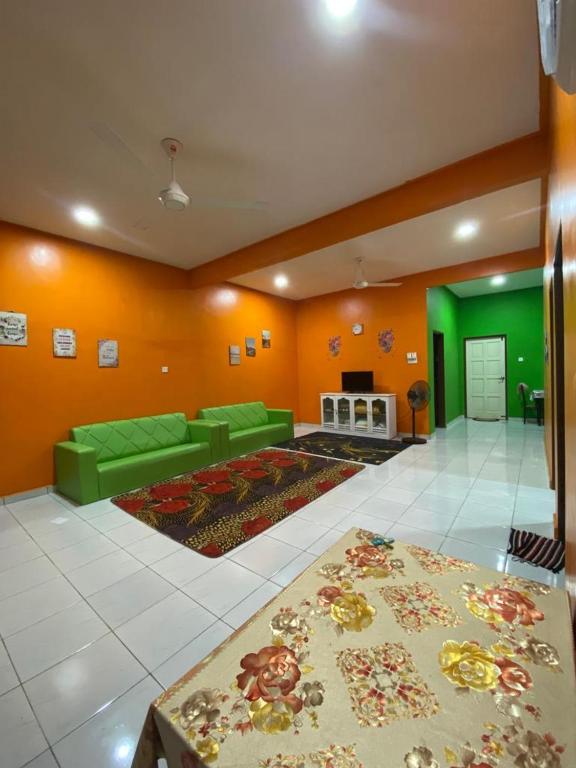 巴佐Pelangi Homestay 2的客厅设有绿色沙发和壁炉