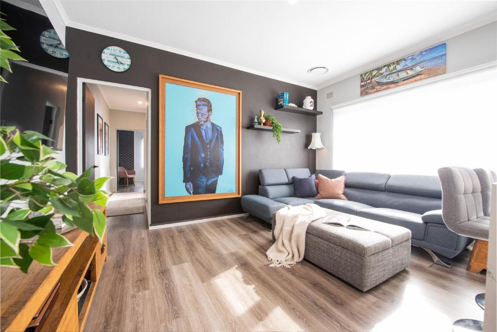 悉尼Bright and Beautiful in Burwood的客厅配有蓝色沙发和绘画作品
