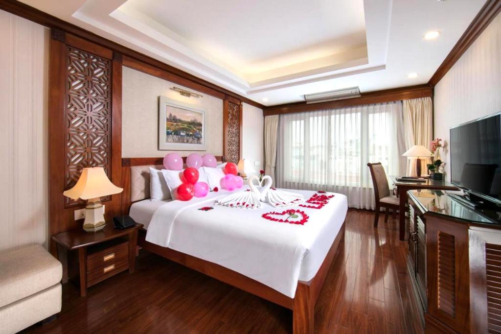 河内Thien Thai Hotel & Spa的一间卧室配有一张大床,上面装有粉红色气球