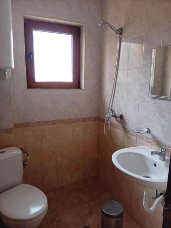金沙马里别墅旅馆的一间带卫生间、水槽和窗户的浴室