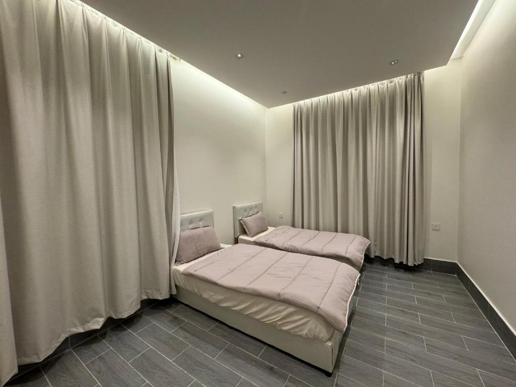 布赖代شاليه الرتاج الفندقي的一间卧室配有一张带粉红色床单和窗帘的床