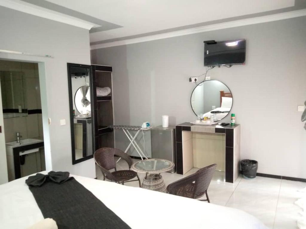 卡萨内Global Guest House的一间卧室配有一张床、一张桌子和一面镜子