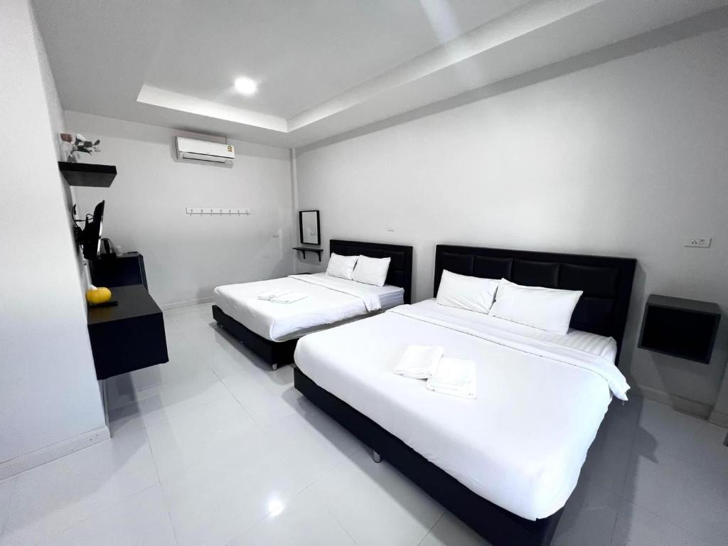 沙缴府บารอนรีสอร์ทสระแก้ว的一间卧室配有两张带白色床单的床