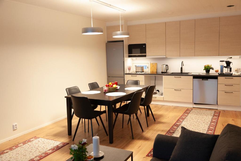 萨翁林纳Saimaan Kodikas A3的用餐室以及带桌椅的厨房。