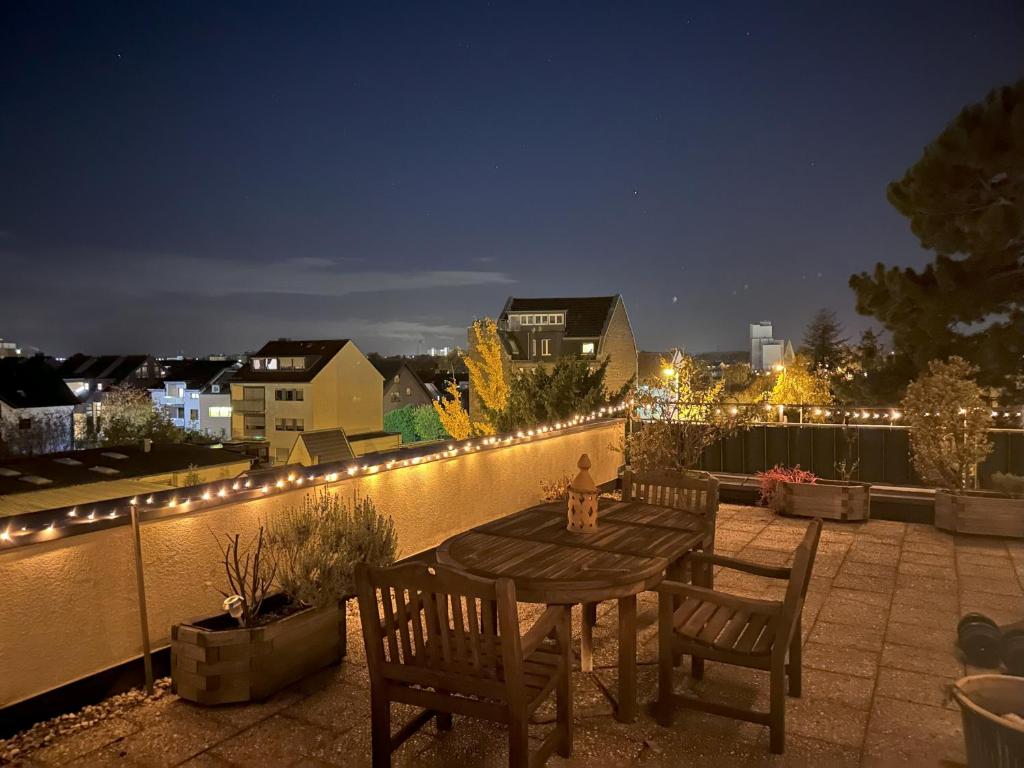韦瑟灵Village Vista Penthouse的夜晚,庭院里摆放着木桌和椅子