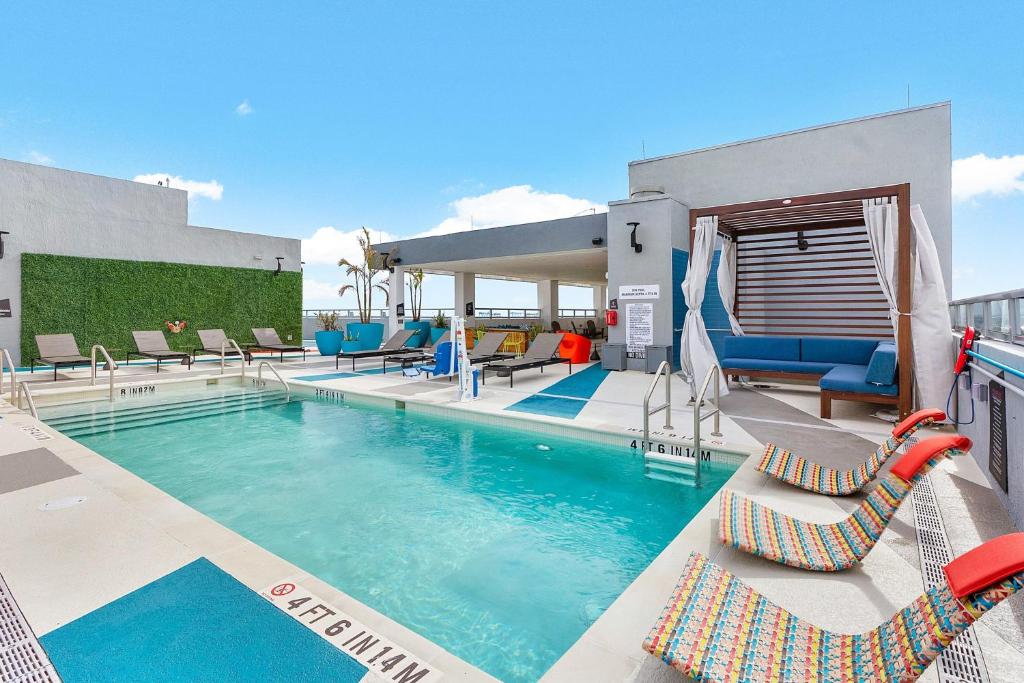 劳德代尔堡Aloft Fort Lauderdale Airport & Cruise Port的一个带躺椅的游泳池,一个度假村