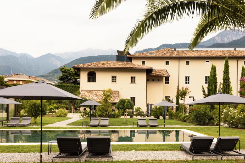 阿科Monastero Arx Vivendi的别墅 - 带带椅子和遮阳伞的游泳池