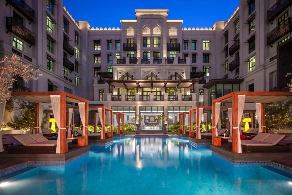 迪拜Hotel Boulevard, Autograph Collection的夜间酒店游泳池的 ⁇ 染