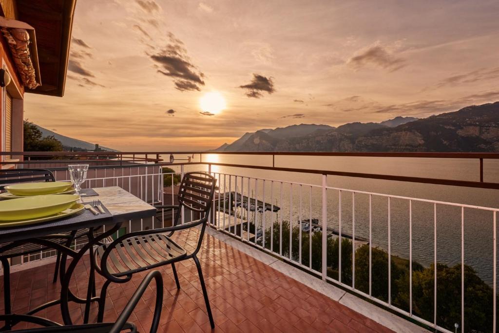 马尔切西内Lake View Luca Apartment的阳台配有桌椅,享有水景。