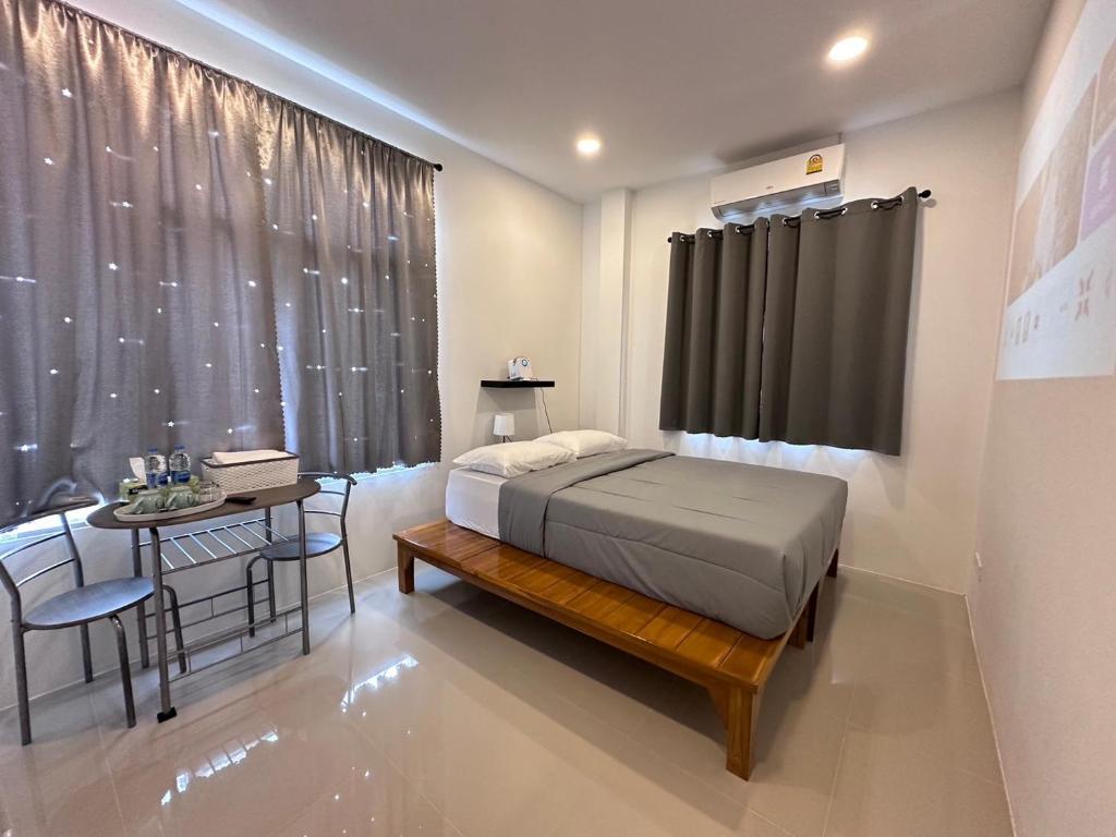 Ban Noi Pho KhamJanis Home的一间卧室配有一张床、一张桌子和一个窗户。