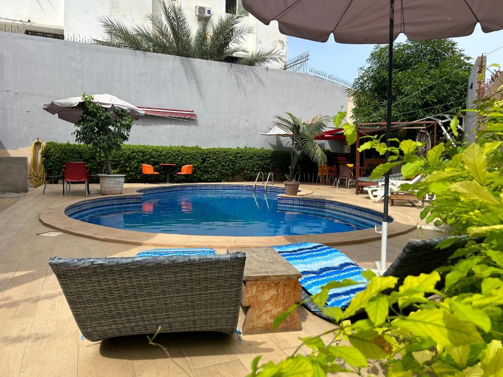 达喀尔Villa Jade的一个带椅子和遮阳伞的游泳池