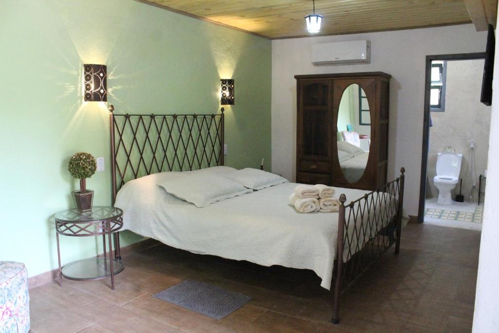 巴纳纳尔Fazenda Dos Coqueiros-Bananal-SP的一间卧室配有一张带镜子的床和卫生间