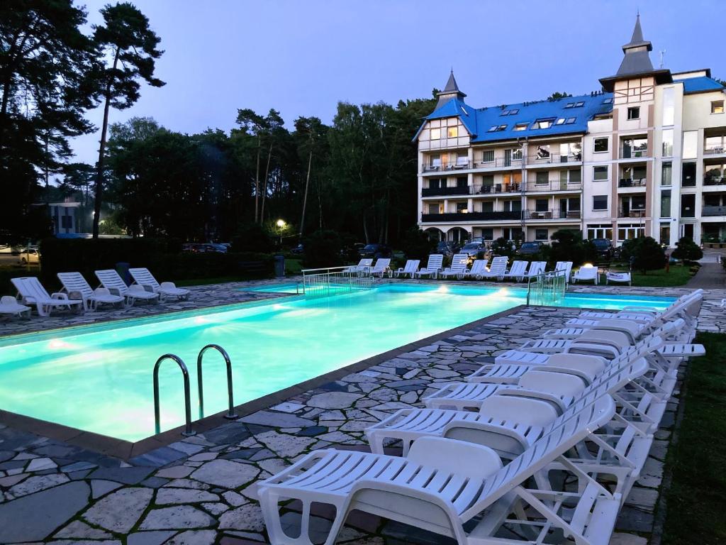 卢克钦Blue Mare BB的一个带白色躺椅的游泳池和一间酒店