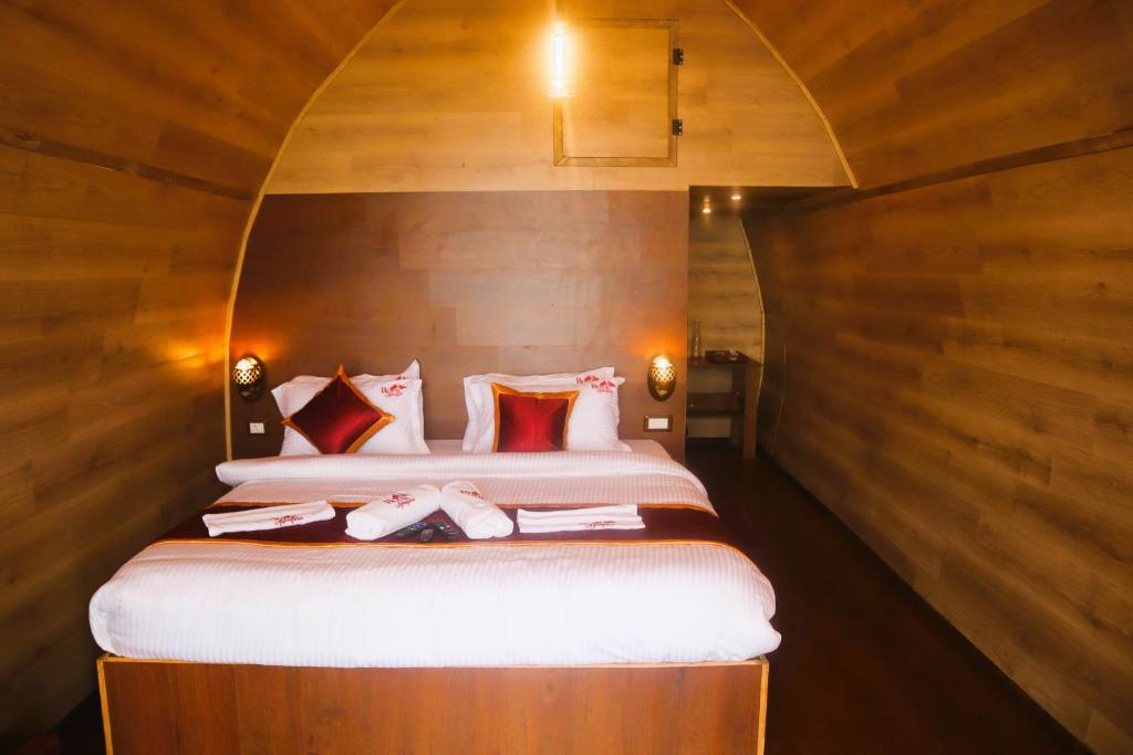 科代卡纳尔Royal Adventures的一间卧室配有一张带木墙的大床