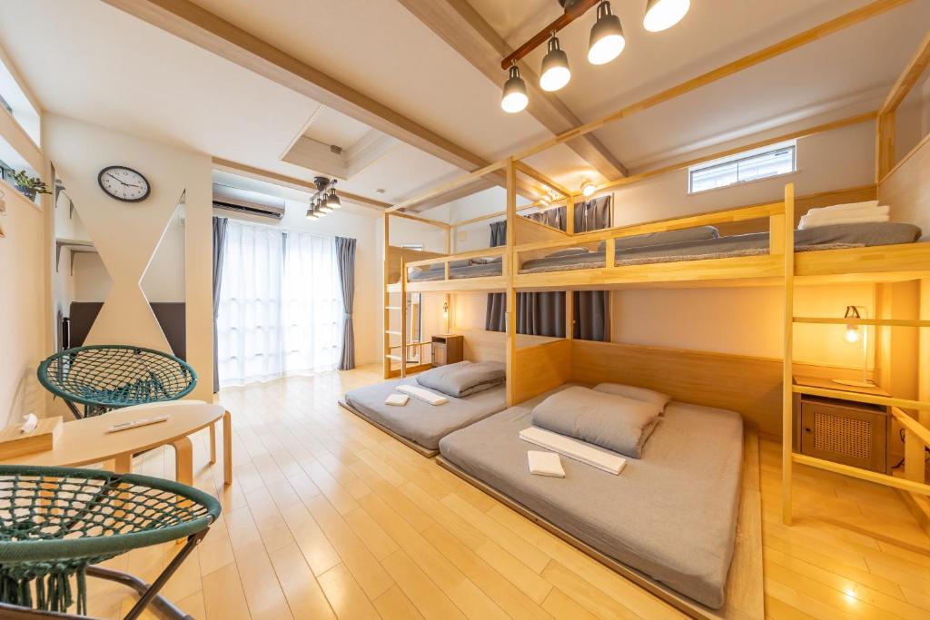 东京HAN'S EBISU - Shibuya - Entire House for Max 10 ppl的客房设有双层床和桌椅。