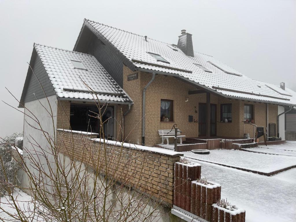 NettersheimFerienwohnung Tina的屋顶上积雪的砖屋