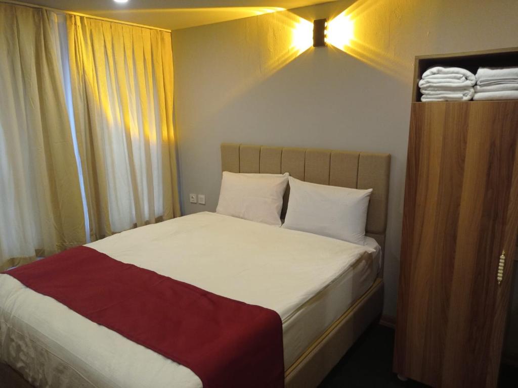 YıldırımGrand Marrakech Hotel的一间小卧室,配有一张带白色床单和红色毯子的床