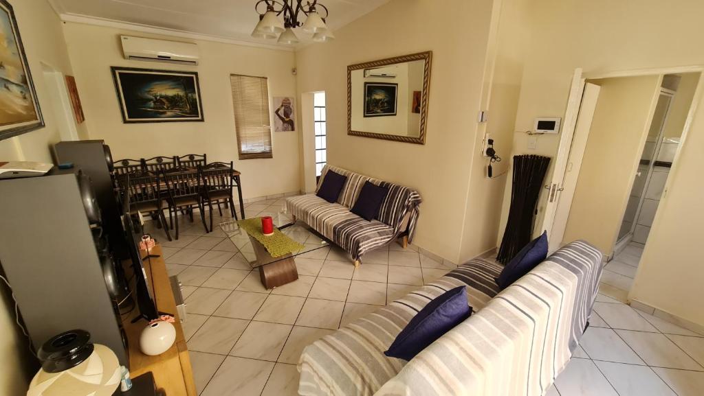 温特和克Garden Oasis Cottage的带沙发的客厅和用餐室