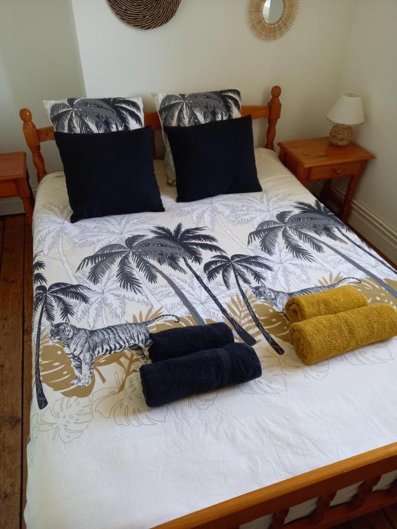 色当Appartement 3 ème étage avec piscine partagée的一张带两个枕头的床,以及老虎和棕榈树