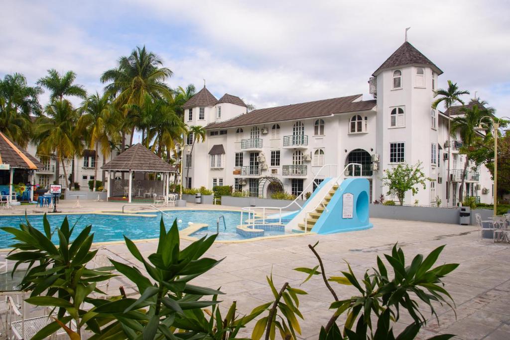 欧丘里欧Czar's Oasis Apt B27 @ Ocho Rios的一个带游泳池和滑梯的度假村