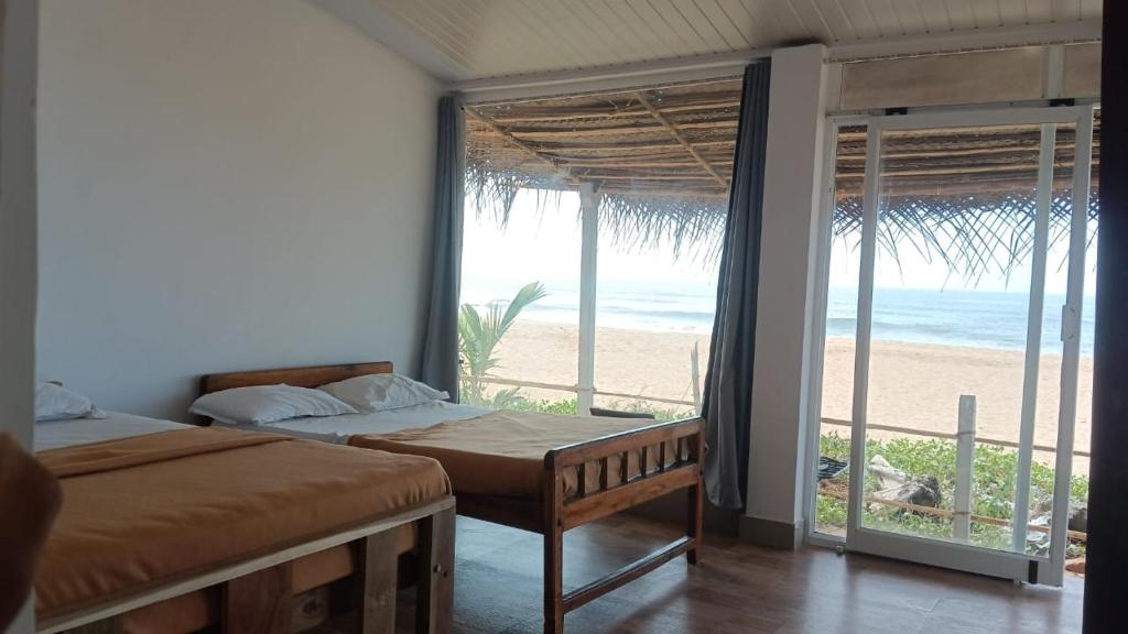 戈卡尔纳The Meraki Beach Resort的一间带两张床的卧室,享有海滩美景