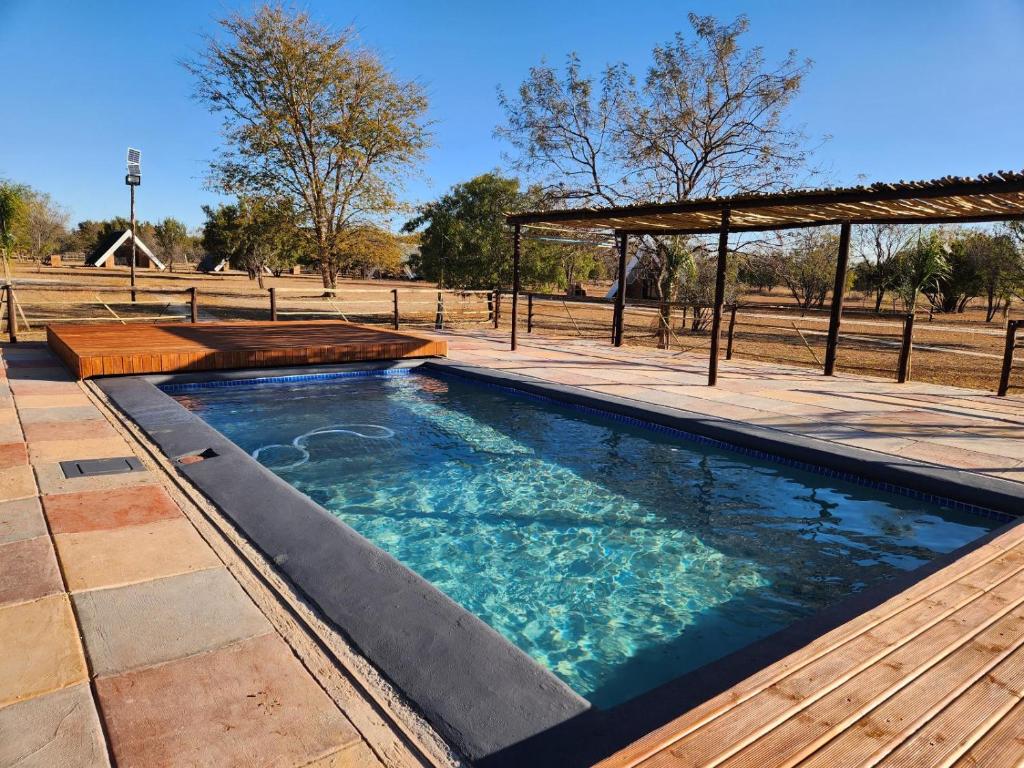 Dinokeng Game ReserveMzimkhulu Ranch & Resort的一个带甲板和凉亭的游泳池