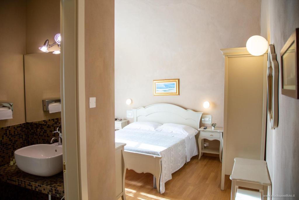 比萨Residenza d'Epoca Relais I Miracoli的一间卧室配有一张床和一个水槽和一个浴缸