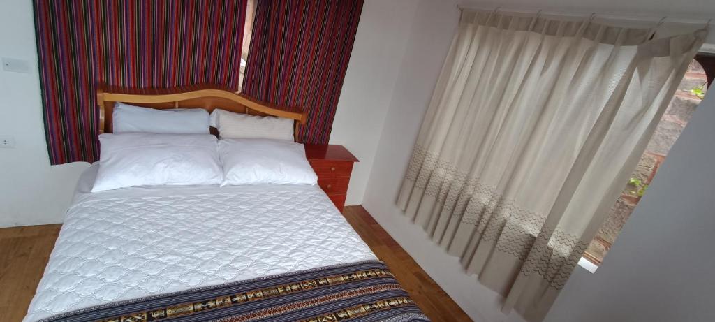 HuillanopampaTaquile Lodge Inn的一间小卧室,配有一张带窗户的床