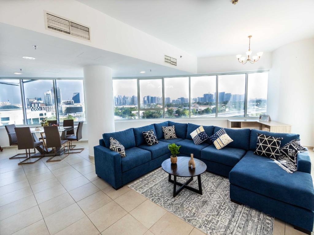 迪拜Avantha By Afi luxury 2BHK apartment的客厅配有蓝色的沙发和桌子
