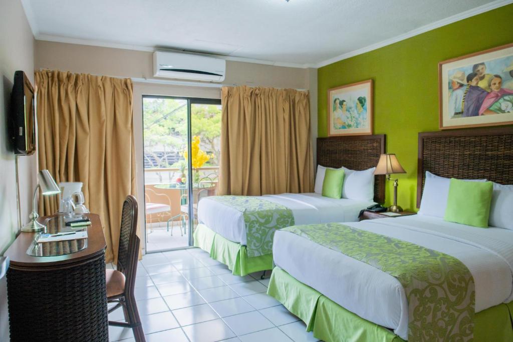 特古西加尔巴贵雅洛斯公寓式酒店的酒店客房设有两张床和一个阳台。