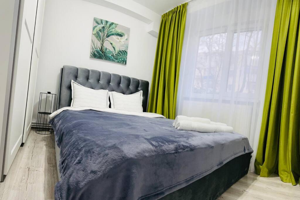 布勒伊拉Apartament Dany的一间卧室配有一张带绿色窗帘的大床