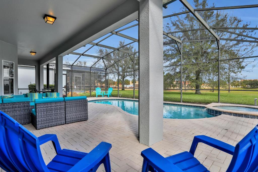 奥兰多Themed Luxury 6BR Getaway with Resort Amenities的一个带蓝色椅子的庭院和一个游泳池
