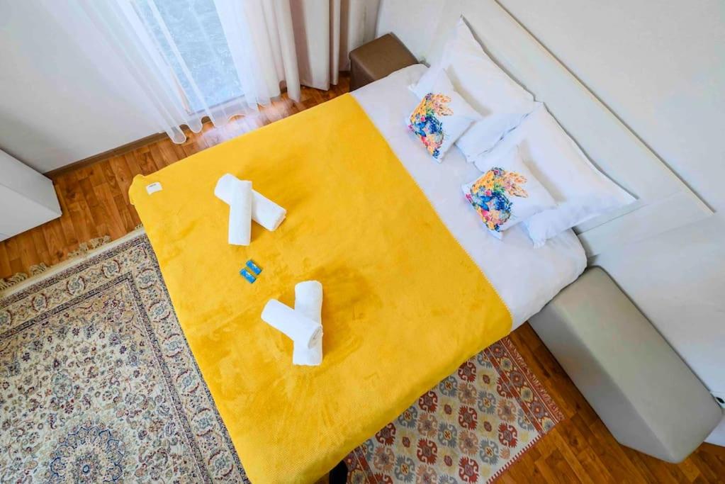 阿拉木图Уют в деловом центре Алматы的一间卧室配有一张带黄毯和十字架的床