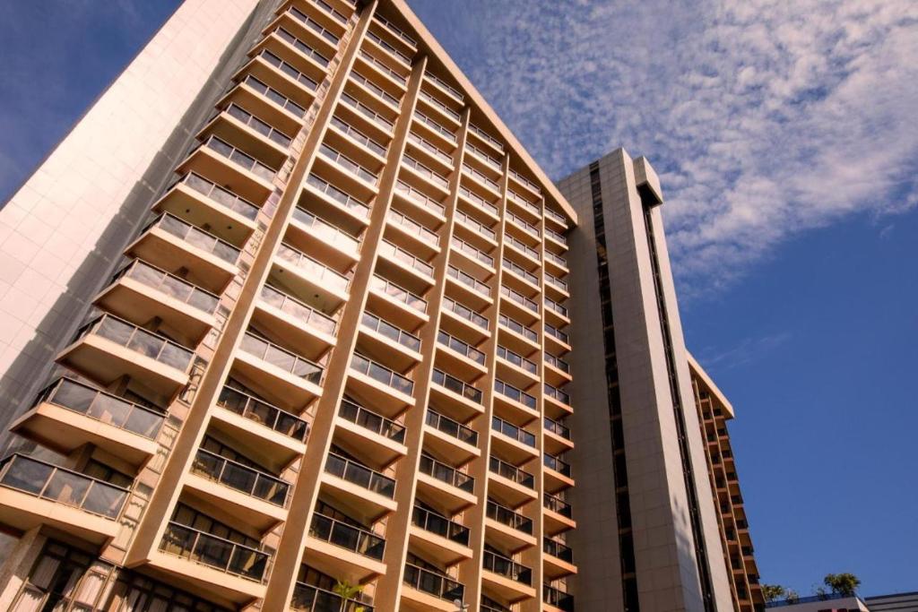 巴西利亚Kubitschek Plaza Hotel - Flat Particular 2的一座高大的公寓楼,后面有天空