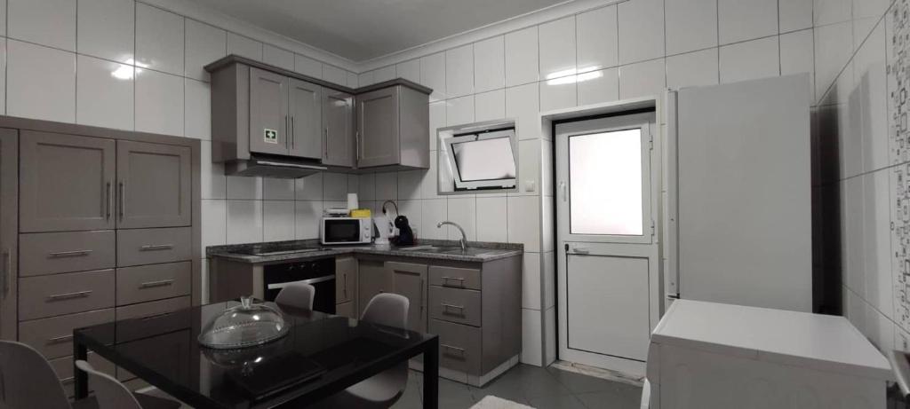 圣克鲁什达什弗洛里什Apartamento da Matilde的带小桌子的厨房和带窗户的厨房