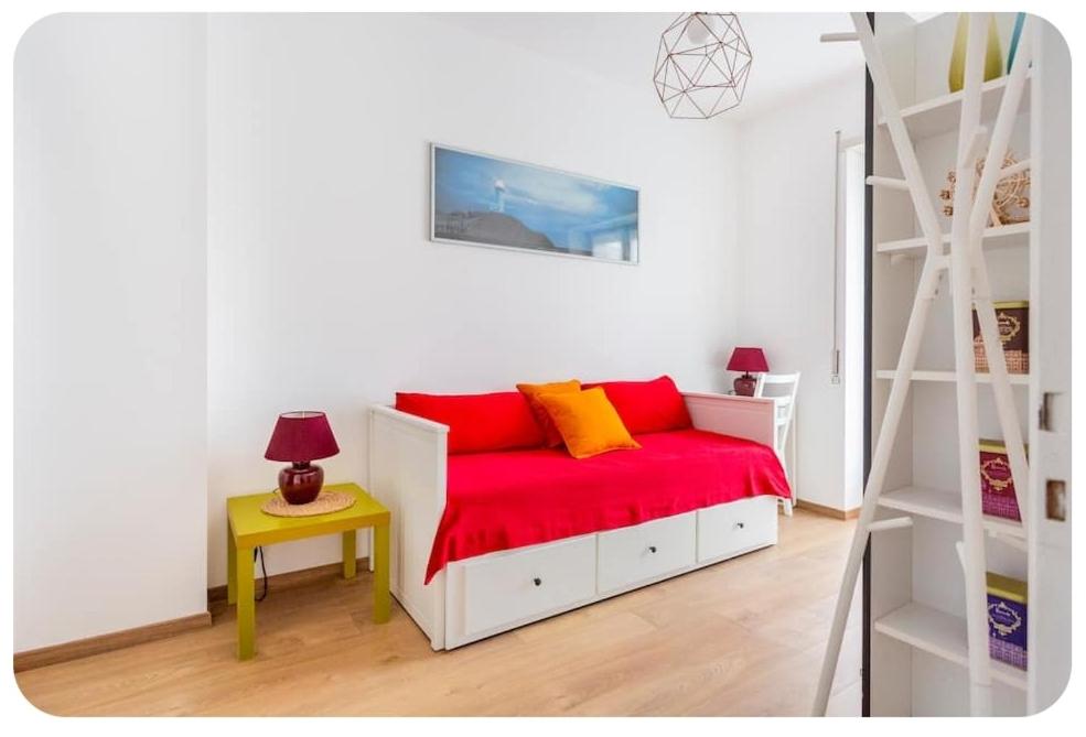 米兰Casa Rizzoli - bilocale vicinissimo M2的一间卧室配有一张带红色床单和梯子的床