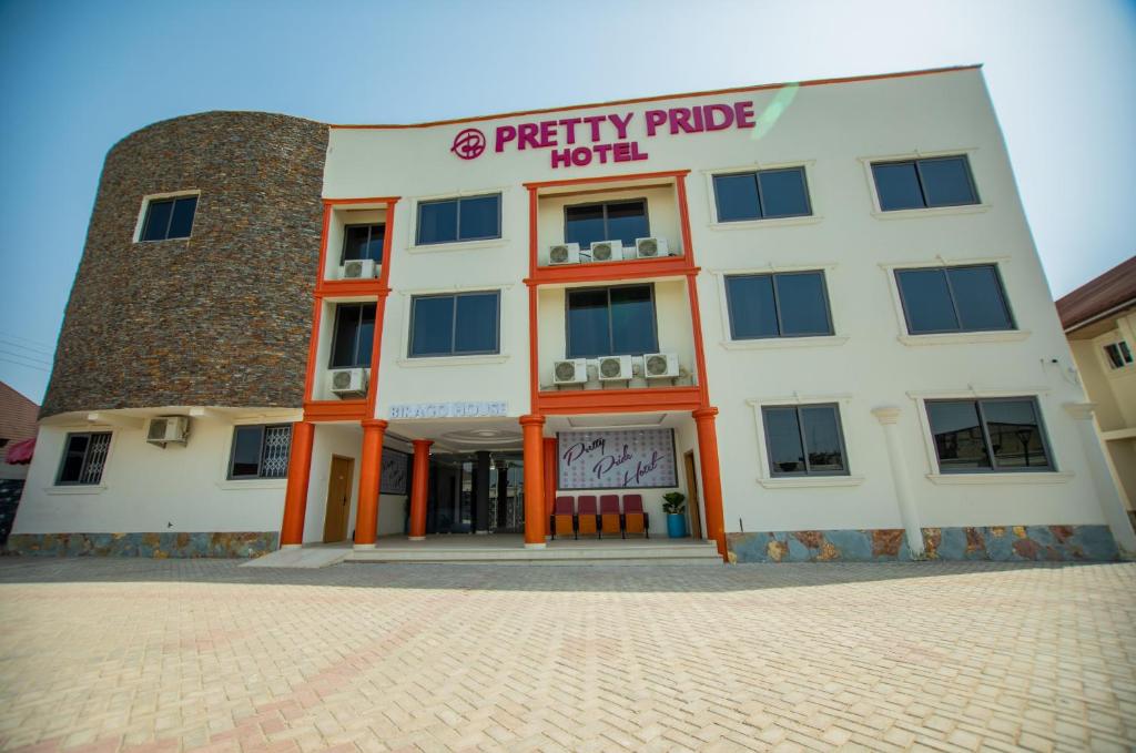 KasiPRETTY PRIDE HOTEL的一座白色的大建筑,上面有标志