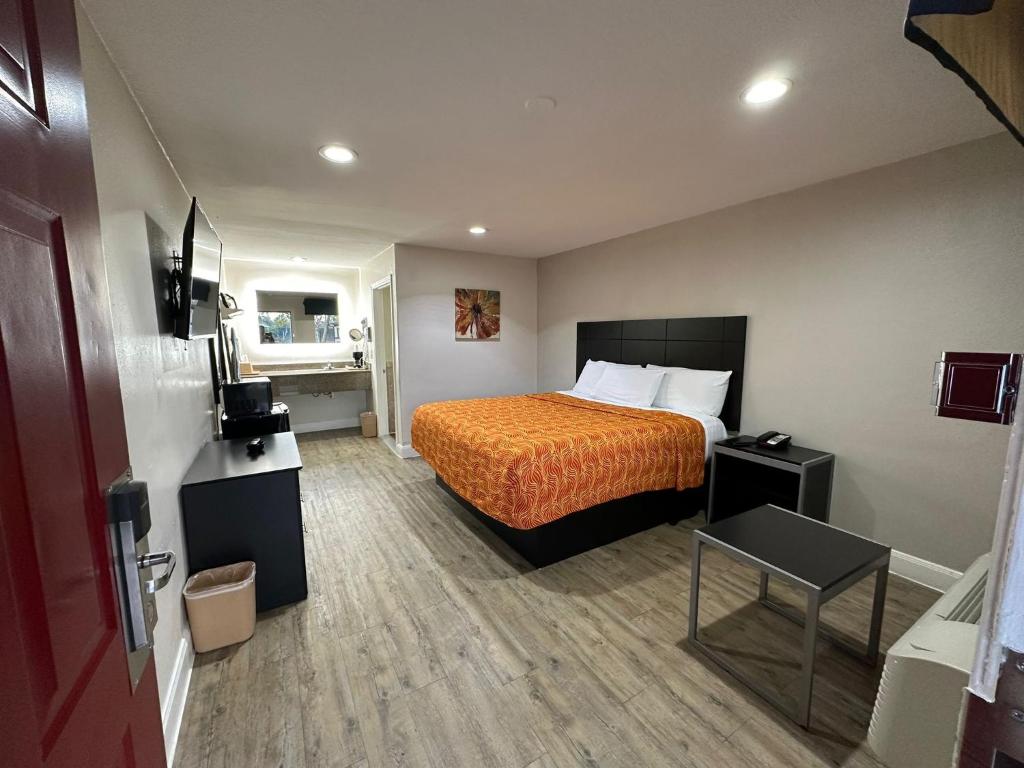 休斯顿Palace Inn I-45 & Bellfort的酒店客房,配有带橙色床罩的床