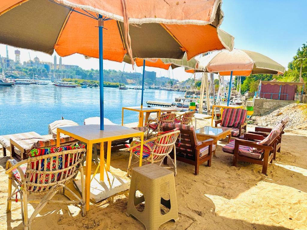 阿斯旺Airkela Nuba Dool2的海滩上一组桌椅和遮阳伞