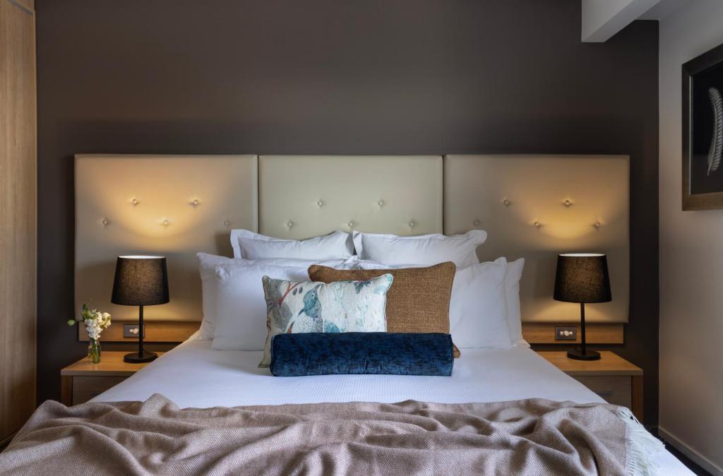 基督城Fable Christchurch的一间卧室配有一张带两盏灯的大型白色床。