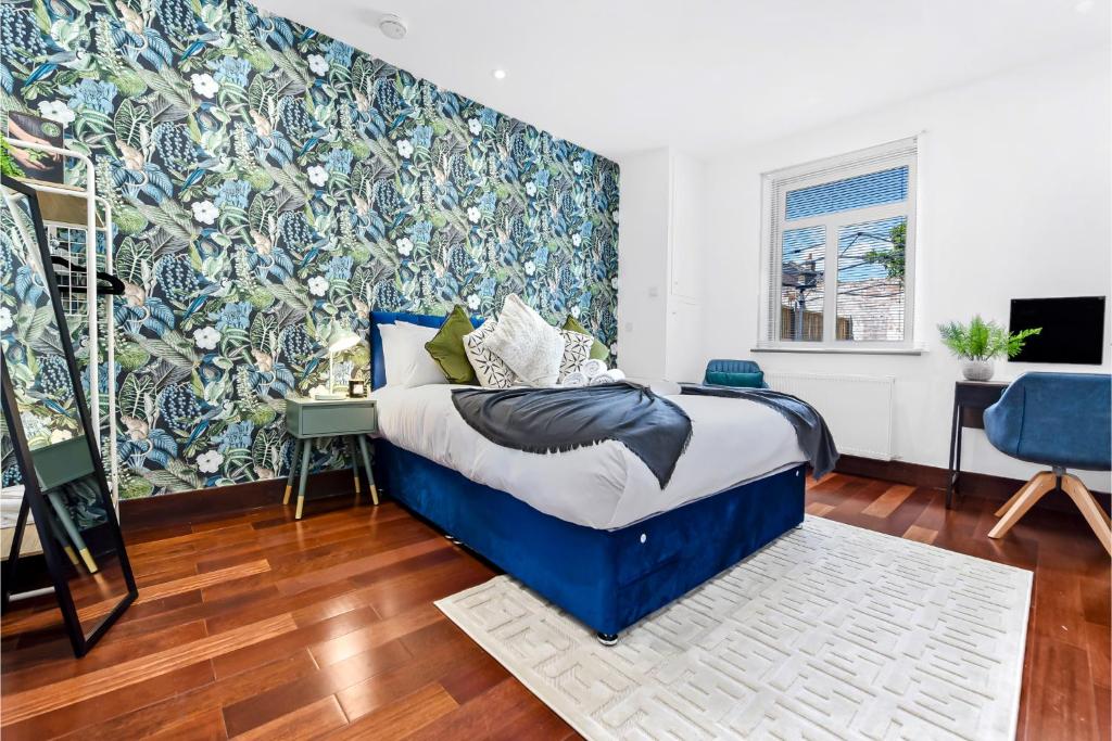 HanwellEnchanted Oasis: A Cozy Flat w/ Botanical Charm的一间卧室设有蓝色的床和蓝白色的墙壁