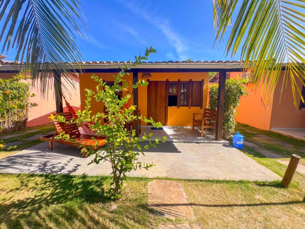 伊塔齐米林Chalés Coco Verde - Praia de Itacimirim的棕榈树的黄色和橙色房子