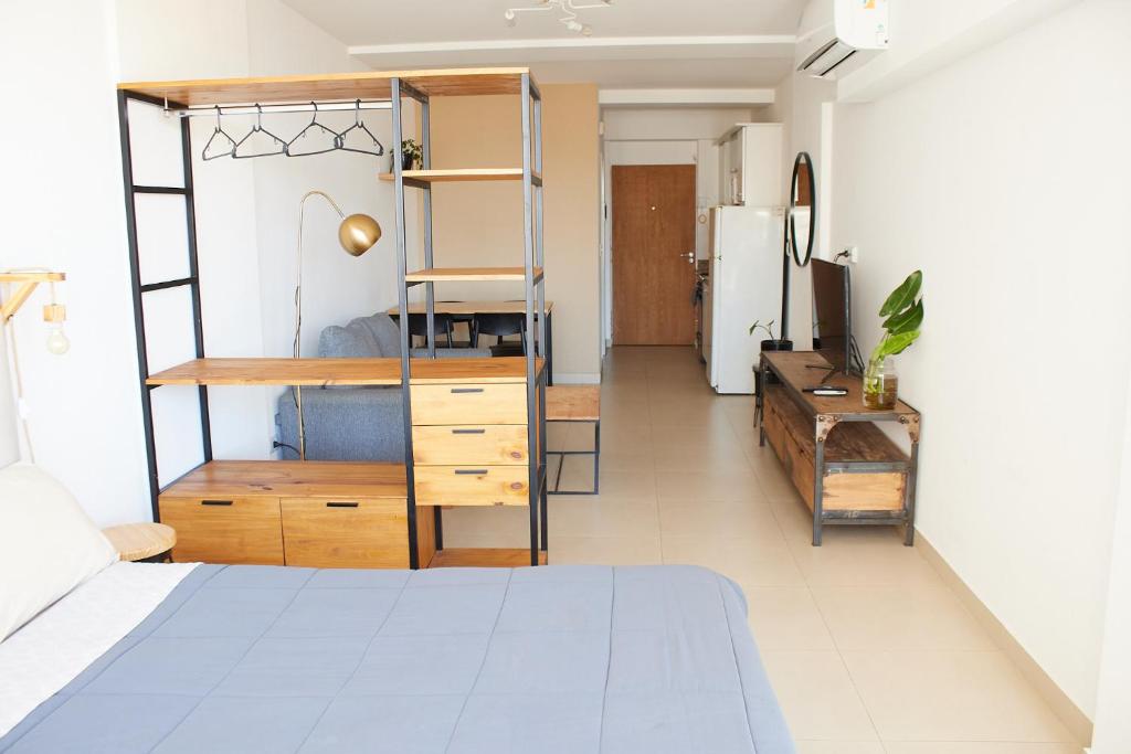 布宜诺斯艾利斯Centro de BsAs! Moderno y confortable con amenities y pileta, 3 pers的一间卧室配有一张床,厨房配有冰箱