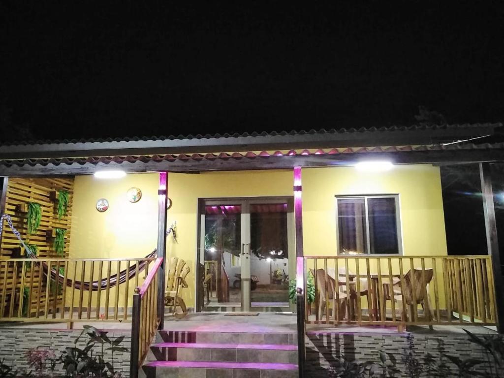 Los SantosBaruch Tropical Ranch的黄色房子,晚上前有紫色楼梯