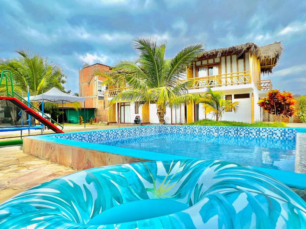 曼克拉Pascana Casa Playa的大楼前带滑梯的游泳池